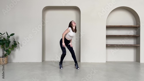 Elegant Woman Dancing in High Heels in Bright Studio