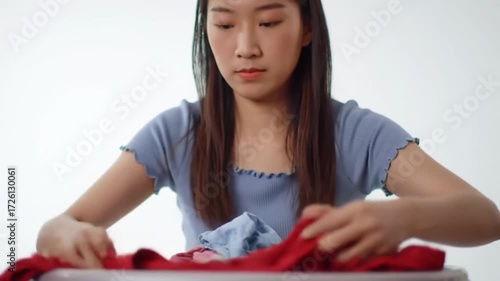 Woman Packing Red Shirt and Other Clothes in Suitcase.