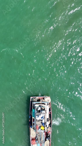Aerial View of Fishing Vessel Navigation Across Turquoise Ocean Water