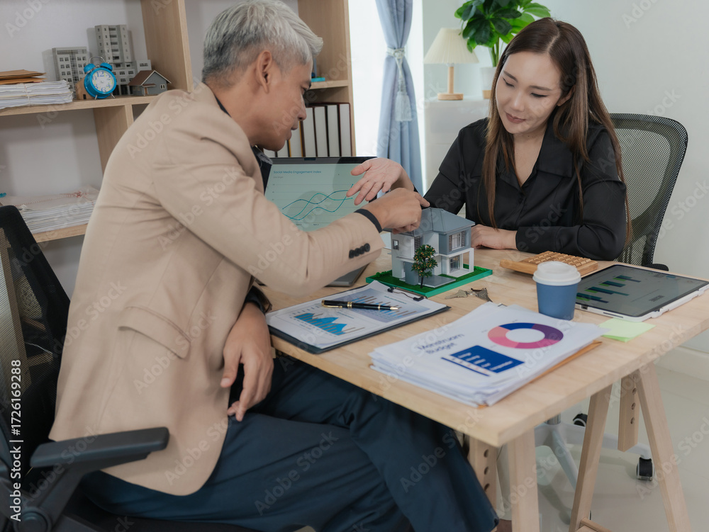 Obraz premium An elderly couple explains how to apply for a mortgage or home insurance. A real estate agent shows details of a house in her file to a young Asian couple looking and interested in buying it. Will buy