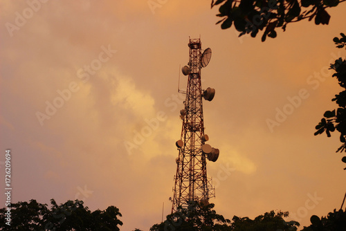 Tower listrik dengan beground matahari terbit dan awan oren yang indah