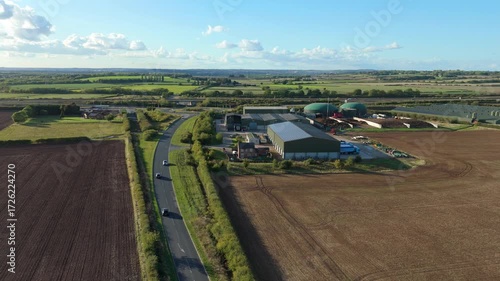 Aerial view of agricultural complex of barns and biogas production domes and storage tanks, bio renewable energy generation from rural landscape, United Kingdom   