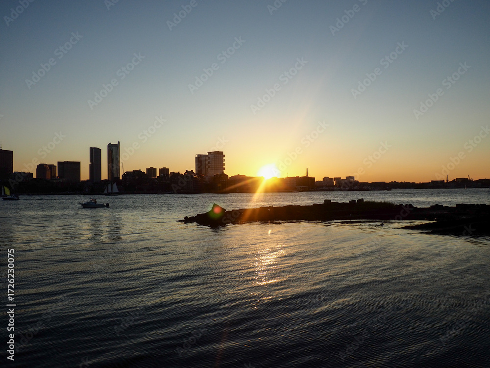 Fototapeta premium A breathtaking city view through the river, where the skyline reflects on calm waters and the urban lights blend with nature’s serenity. This scene captures the harmony between city life and natural