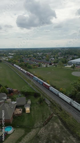 Wallpaper Mural Drone tracks freight train moving through countryside on cloudy day Torontodigital.ca