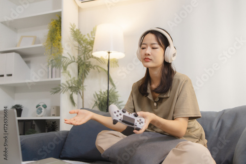 Foto A young woman wearing headphones looks frustrated while playing video games at home