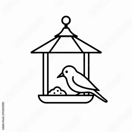 Bird feeding on seeds in a bird feeder with simple design  