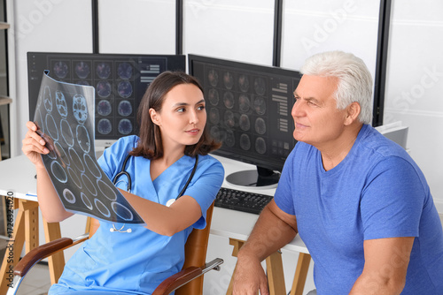 Female doctor showing x-ray scan to senior patient in medical office