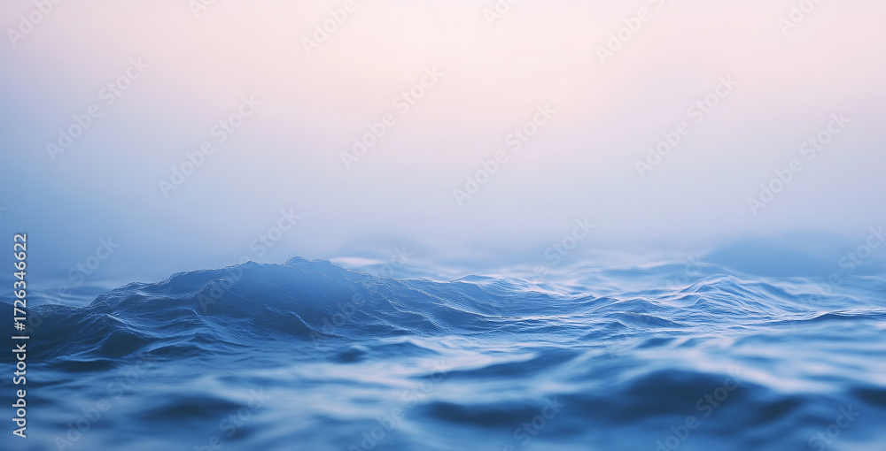 Fototapeta premium Gentle ocean waves ripple and roll beneath a foggy sky at dawn creating a serene seascape.