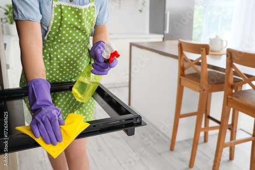 Housewife cleaning oven in ...