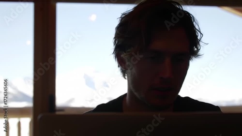 young man looking out window