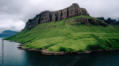 Moody Coastal Landscape Green Hill and Dark Blue Water Under an Overcast Sky