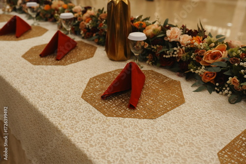 A beautifully decorated dining table with floral arrangements and napkins.
