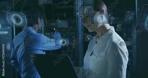 Engineer running laptop diagnostic with holograms mapping network as technician reseating cables