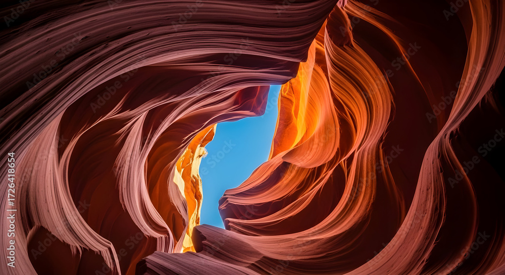 Obraz premium Swirling Red Rock Formation with Blue Sky View From Below