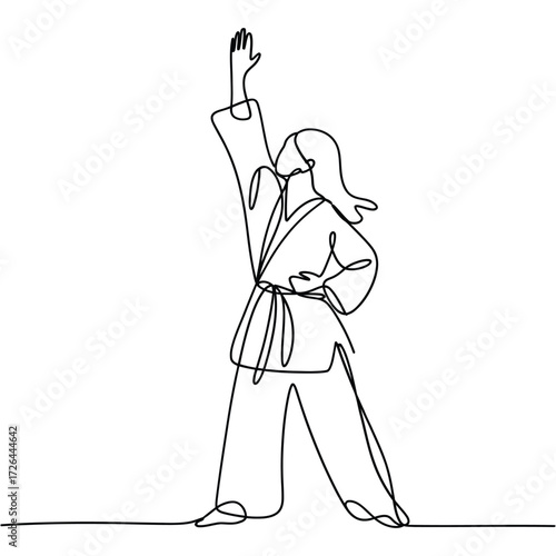 Martial artist in gi with raised fist and determined stance