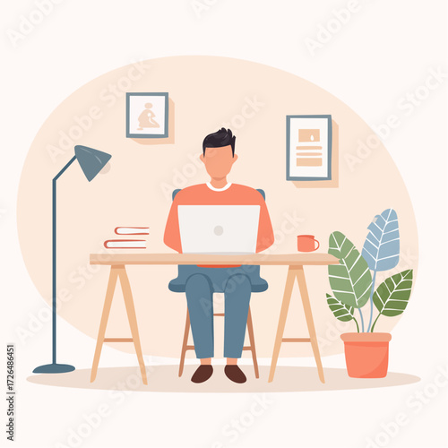 Young freelancer man working on a laptop computer at his desk in a comfortable and modern home office environment