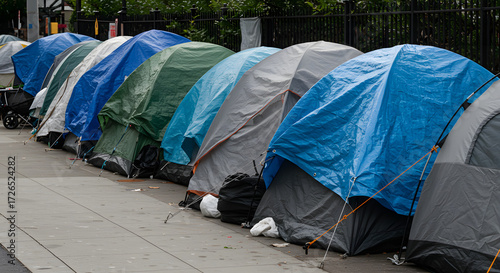 Row of makeshift tents set up on a city sidewalk for homeless people