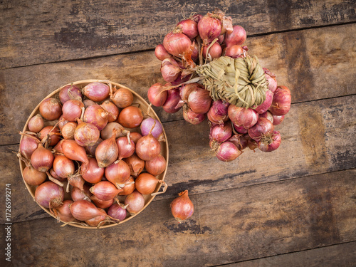 Shallots in a wood bowl on wooden background.
