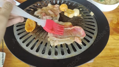 apply seasoning on sliced beef grilling meat barbeque in a table grill