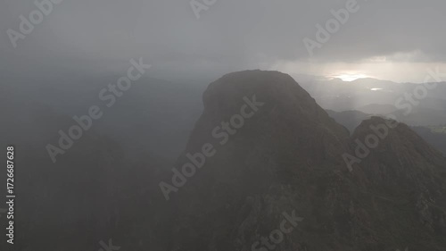 Drone view of Aiako Harriak three peaks in a foggy evening with the clouds almost touching the peaks, at the Basque Country.