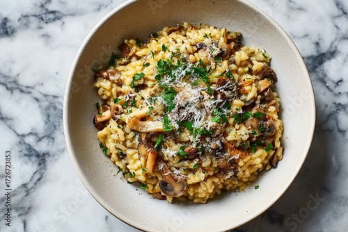 Wild mushroom risotto with parmesan and parsley in a shallow bowl on a marble surface, creamy texture, warm tones