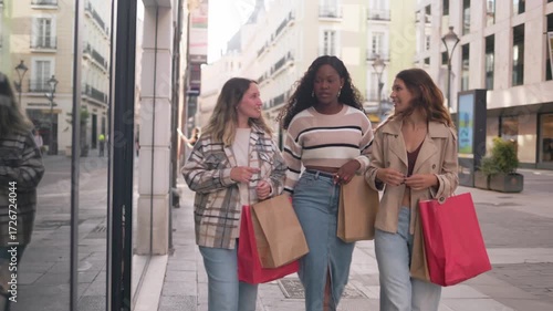 Three happy multiethnic women shopping together in a city