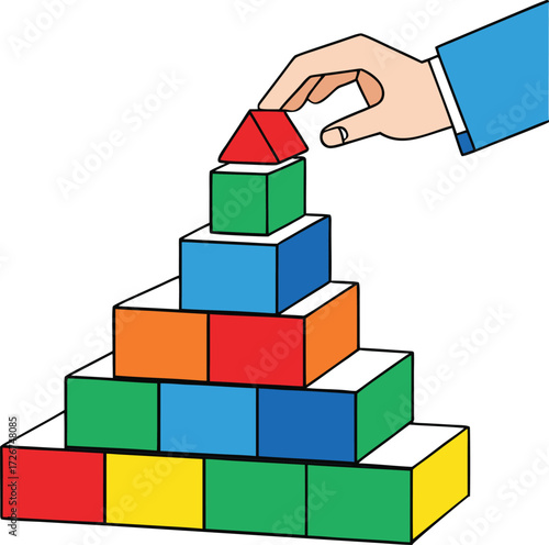 Hand stacking colorful building blocks into a pyramid
