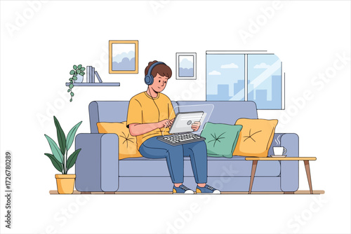 Young man in headphones working on a laptop, relaxed home office setting.