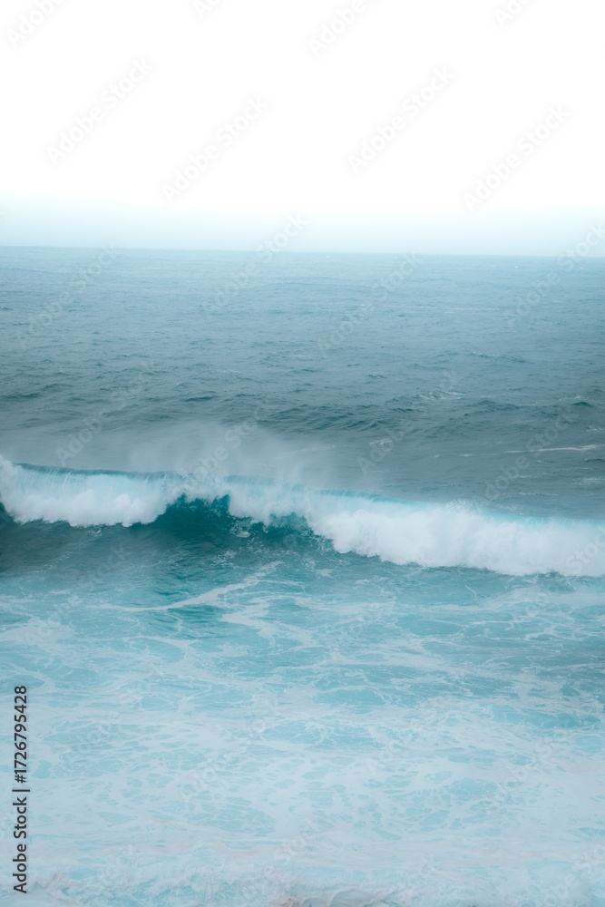 Fototapeta premium Aerial view of ocean waves, boats and sunset