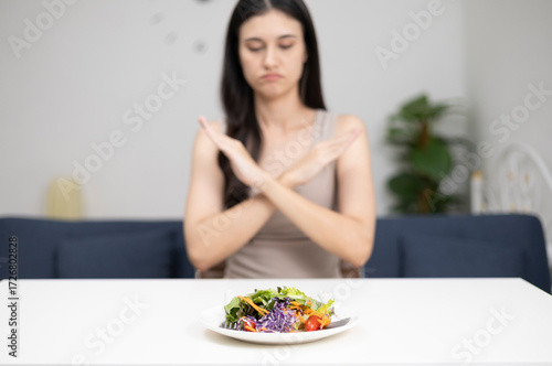 A young woman with no appetite eats a boring and unpalatable breakfast.