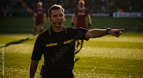 A soccer referee in black uniform pointing his finger on the field during a soccer game action scene
