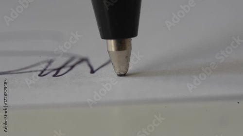The tip of the inexhaustible pen draws lines on the paper as a macro close up