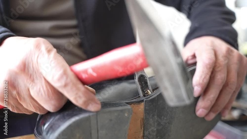 Old shoe master separates the base of the shoe with hammer