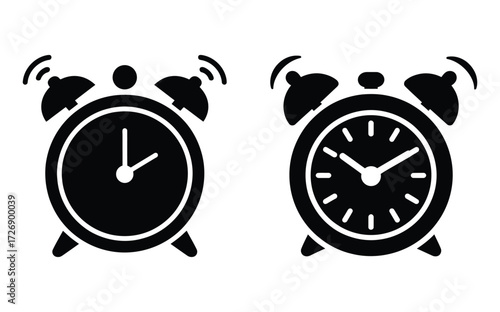 Two contrasting alarm clocks one black silhouette and one with white face and hands