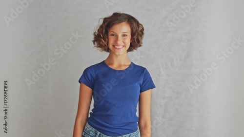 Ambitious smiling female looking upward directly at camera showing inspired motivation determination and hopeful determination, isolated white background