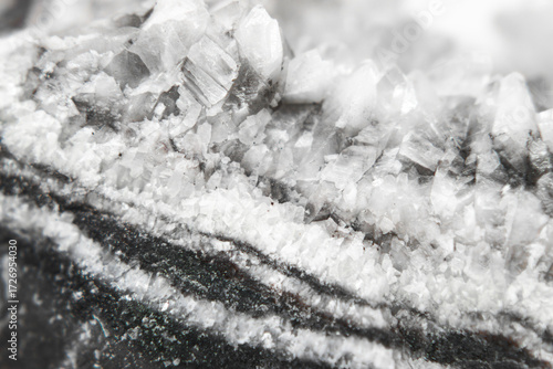 Macro of black and white quartz mineral with layered stone texture and translucent crystal formations in the center. Perfect for geology, mineralogy, natural backgrounds and jewelry design.