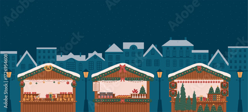wooden stalls at Christmas market in city at night with festive lights, gingerbread, mulled wine, hot dogs and snowy atmosphere