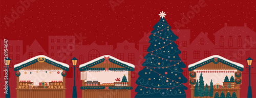 market stalls with big Christmas tree at night with festive light and snowy atmosphere