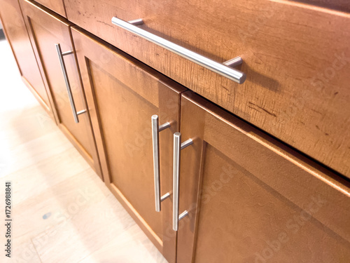 Quadro em tela Close-up of cabinetry with metal bar pulls in warm kitchen