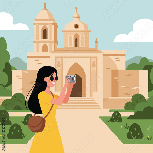 Woman taking a picture of a church in a park-like setting.