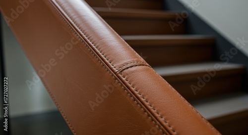 Closeup view of tan leather staircase handrail