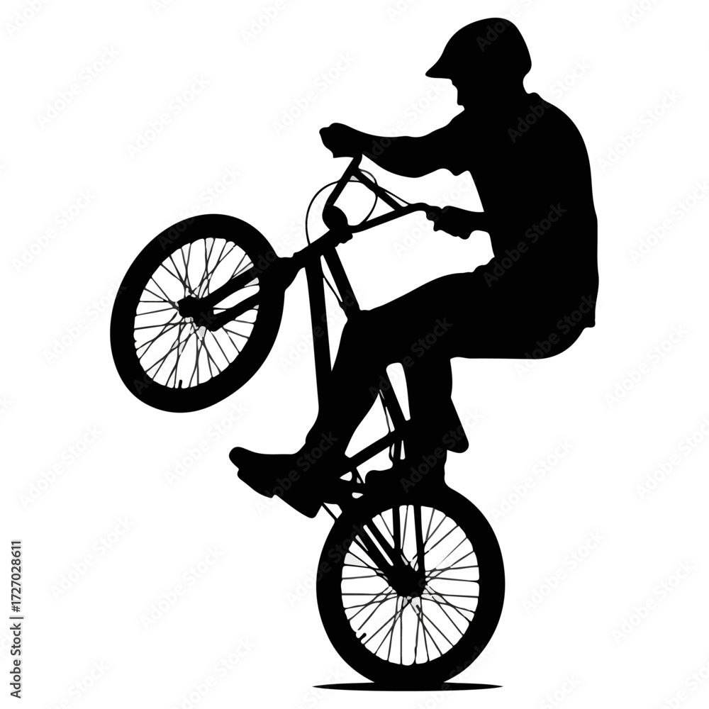 Fototapeta premium Silhouette of a BMX rider performing a wheelie trick.