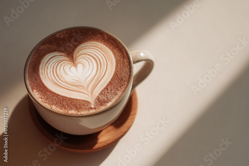 A cup of hot coffee latte art with heart sign foam on table background. Creative layout and concept of coffee shop branding and business