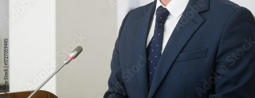 Photos Anonymous man in business suit speaking into microphone at conference, symbol of leadership, politics, education or law