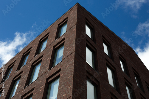 Wallpaper Mural View of modern brick building's corner, showcasing clean geometric facade with horizontal window patterns. The sharp lines and contrast with the sky emphasize the architectural design Torontodigital.ca