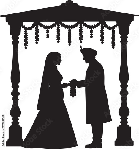 Indian wedding couple exchanging garlands under a decorated canopy