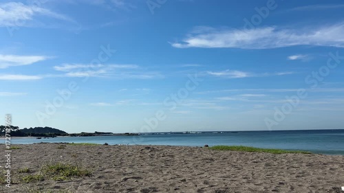 真夏の青い空と岬の沖で白い波がきれいに割れているビーチ