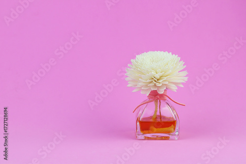 luxury aroma scent flower reed diffuser glass bottle is on pink table to create romantic and relax ambient in bedroom with grey cracked cement wall background in morning of happy valentine day scents