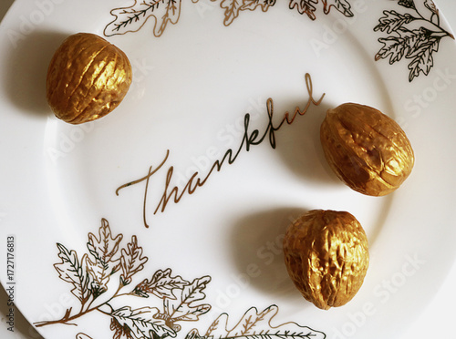 Thanksgiving plate closeup with walnuts and gold leaf details