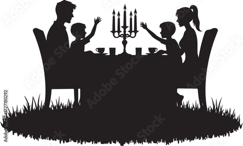 Family silhouette at candlelit dinner table with grass